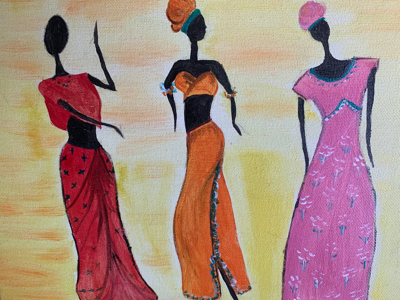 Three women wearing colorful dresses