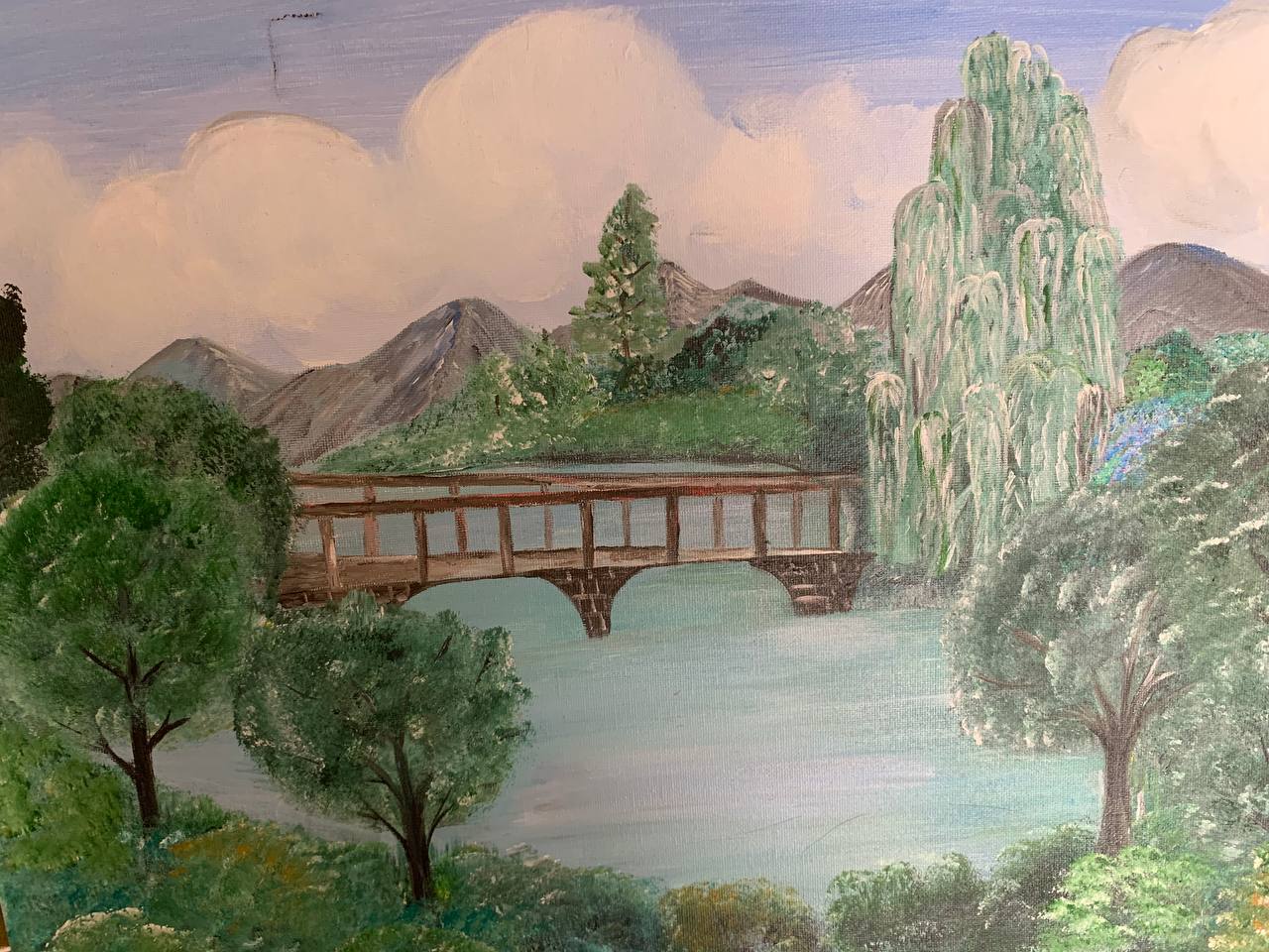 Bridge over water with willow trees