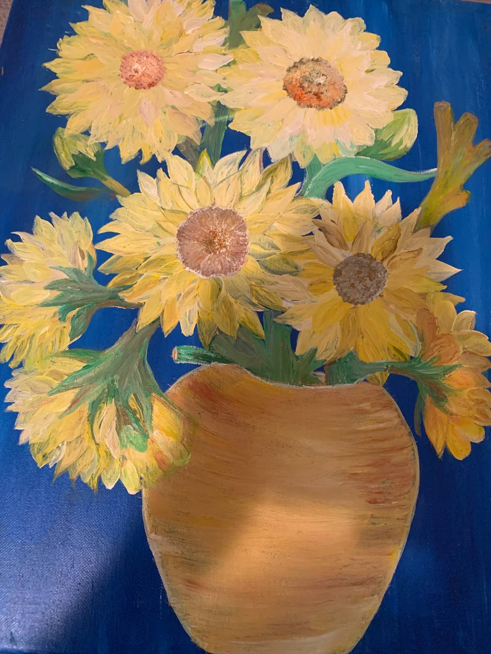 Sunflowers in a vase against blue background